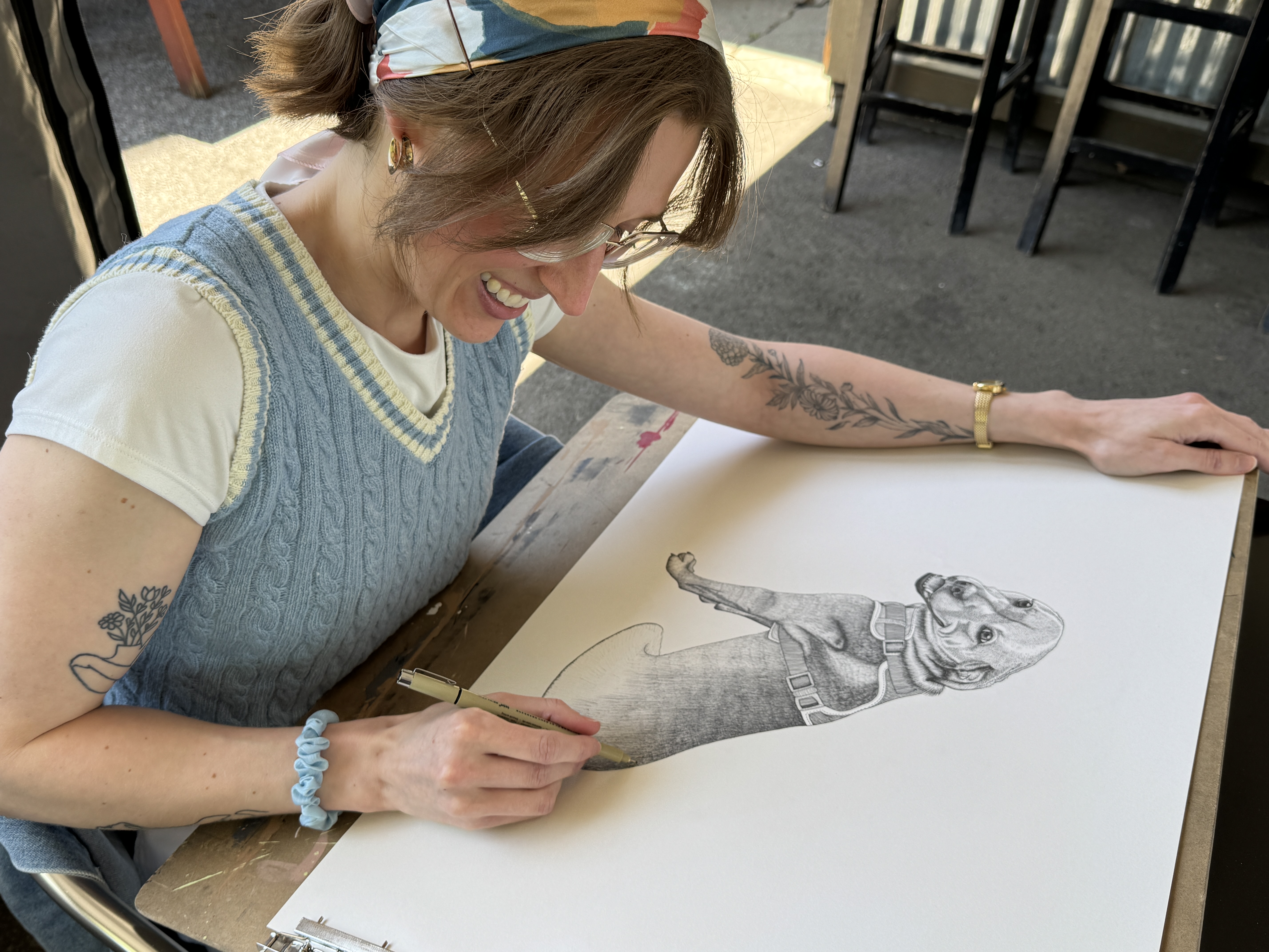 Haley working on a pen and ink portrait at an outdoor table