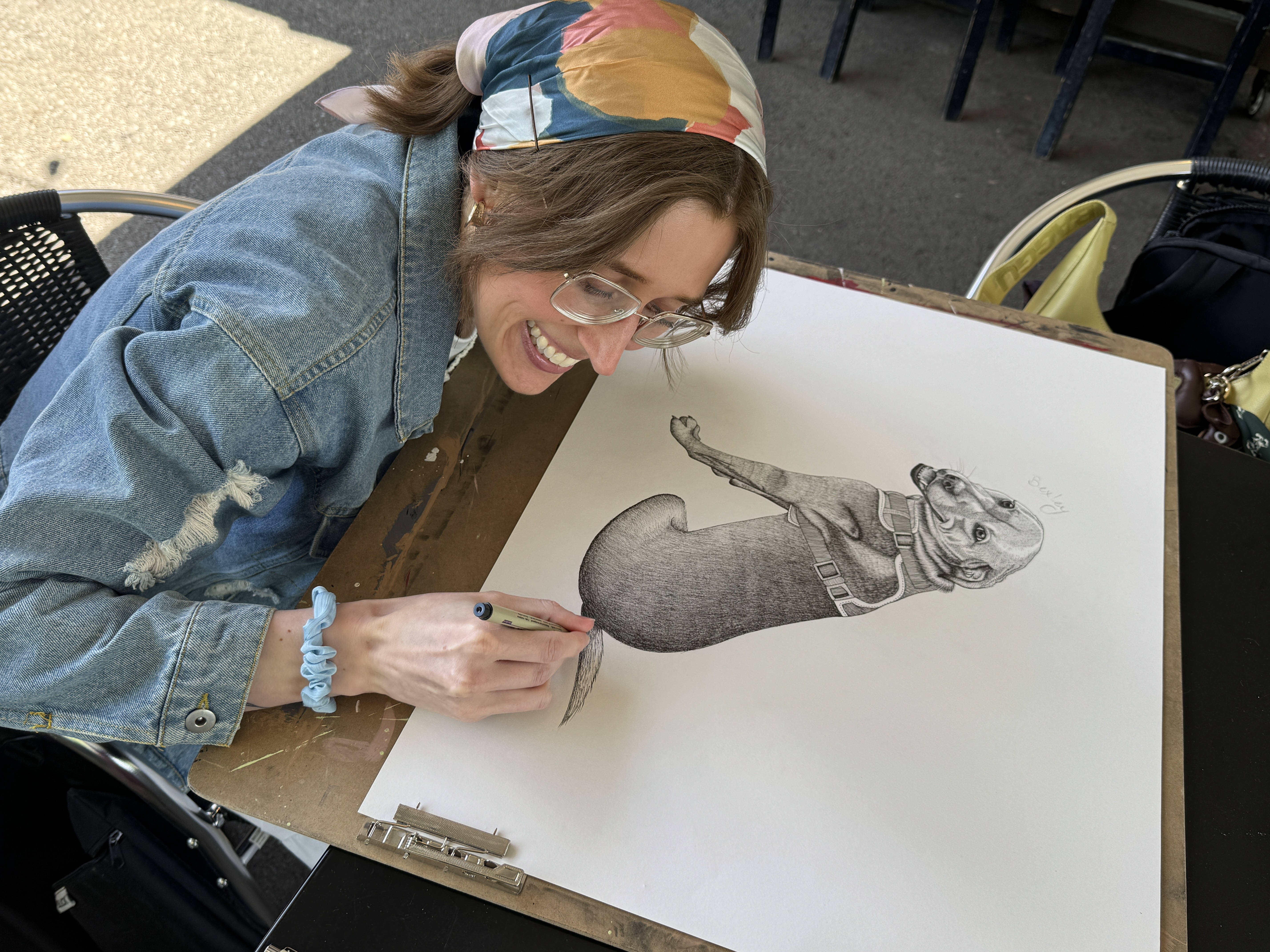 Haley drawing a pen and ink pet portrait outdoors